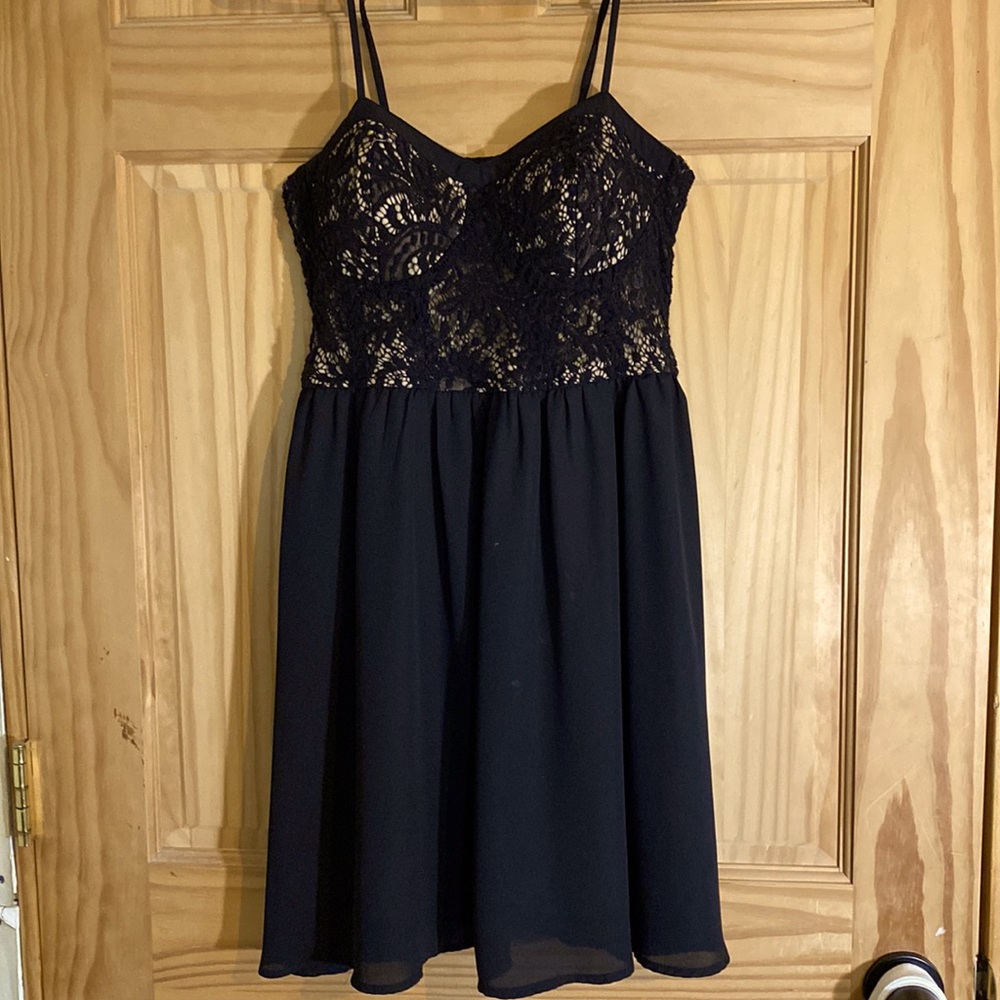 A medium short dress that has a silky like texture with lace on the top.